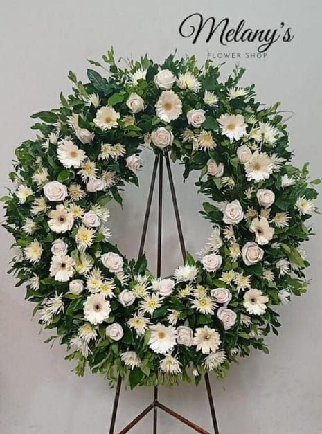 Corona de condolencias con rosas y flores blancas